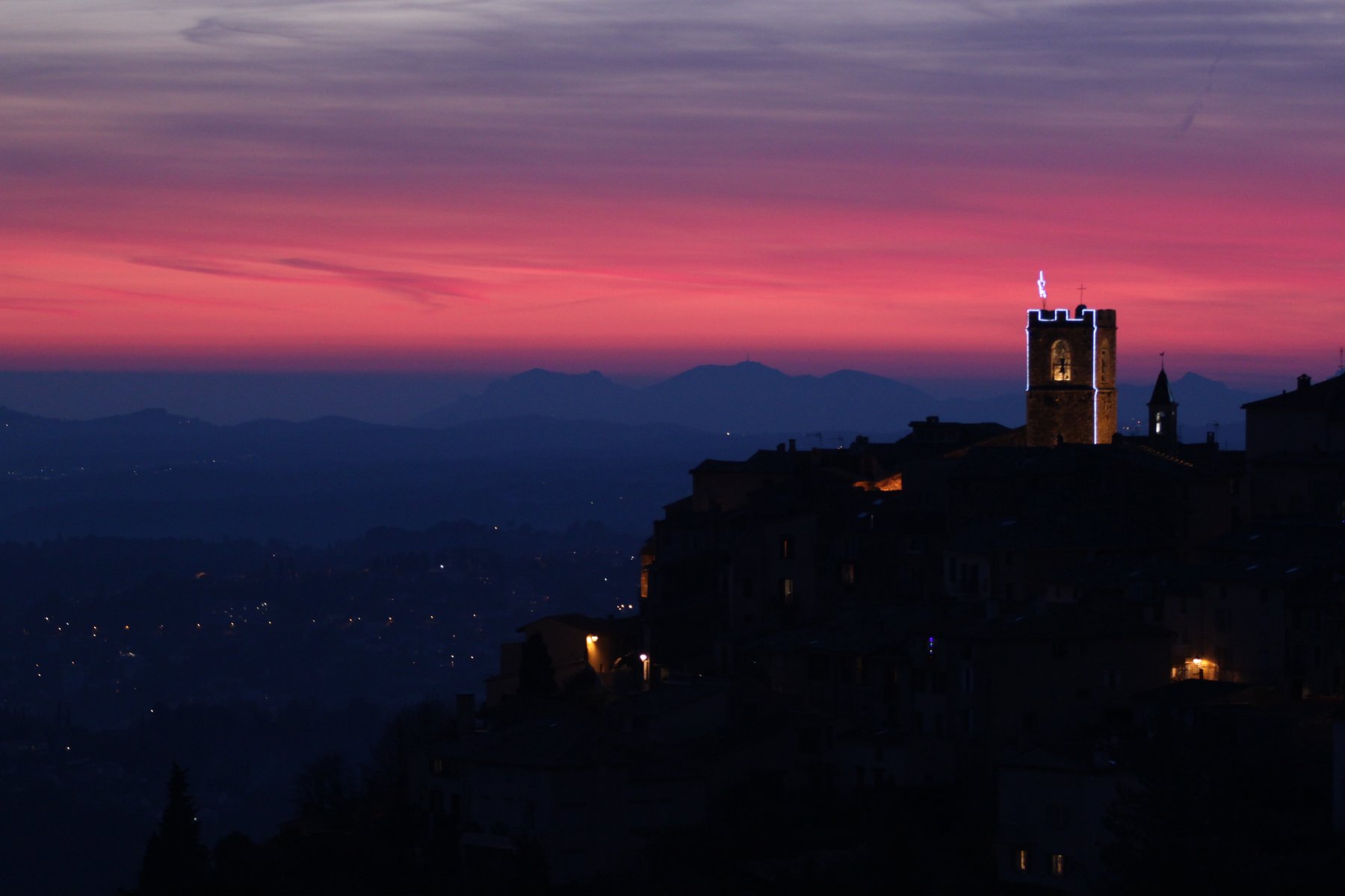 The village and its bell tower at pink dusk